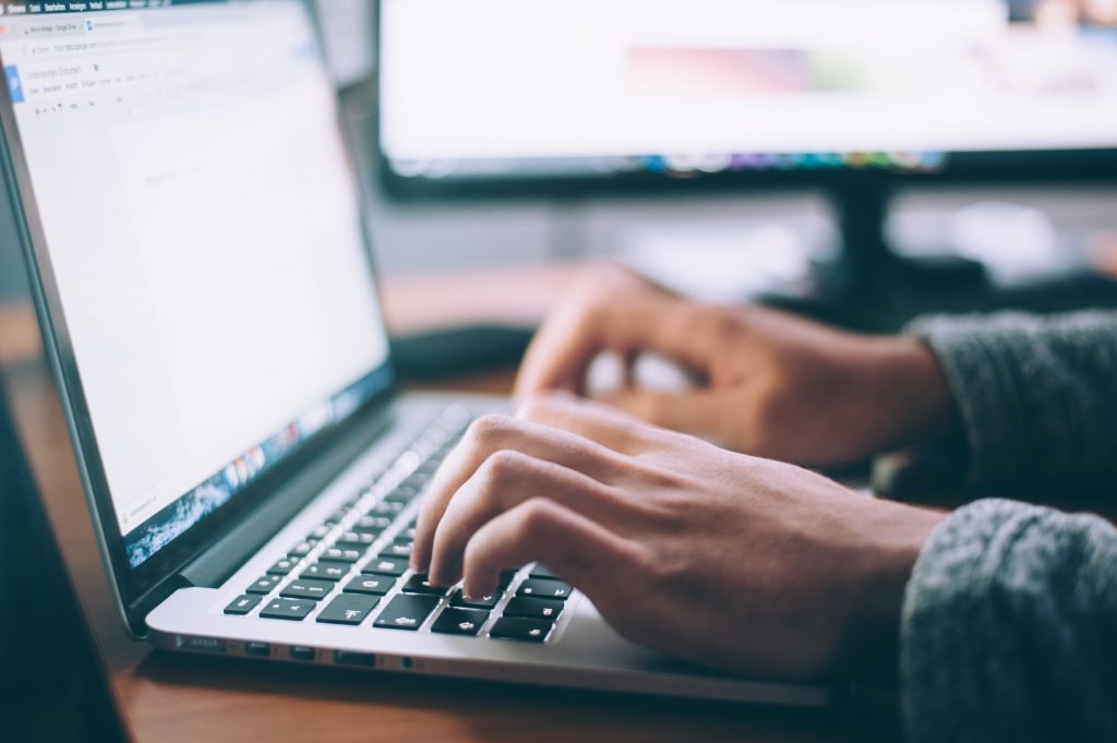 Image of someone typing on their laptop