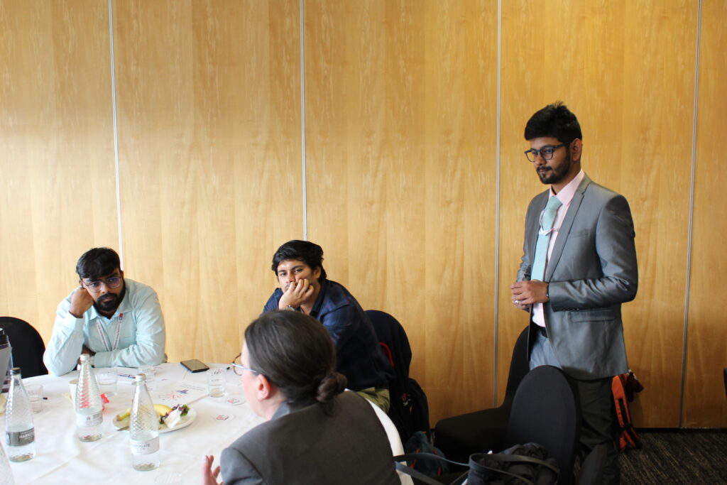Attendees at a table discussing a presentation together